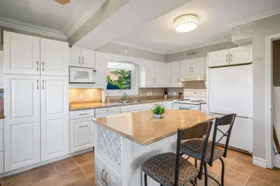 a kitchen with white cabinets and a table and chairs at Vineyard Home Pet Friendly NOTL Large Backyard in Niagara on the Lake