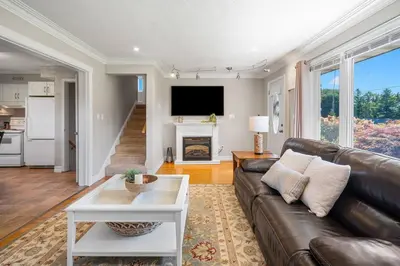 a living room with a leather couch and a table at Vineyard Home Pet Friendly NOTL Large Backyard in Niagara on the Lake