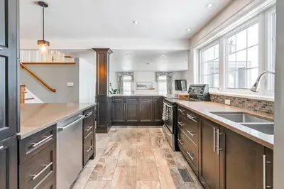 a large kitchen with wooden cabinets and a sink at Peaceful 3Bdrm Spacious NOTL Home mins to Town in Niagara on the Lake