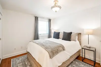 a white bedroom with a large bed and a window at Peaceful 3Bdrm Spacious NOTL Home mins to Town in Niagara on the Lake