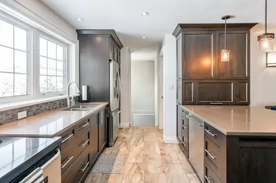 a large kitchen with wooden cabinets and a sink at Peaceful 3Bdrm Spacious NOTL Home mins to Town in Niagara on the Lake