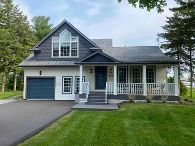 a house with a porch and a garage at Peaceful 3Bdrm Spacious NOTL Home mins to Town in Niagara on the Lake