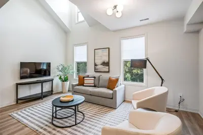 a living room with a couch and chairs and a tv at 1 Bdrm Luxe Apartment in Niagara in Niagara on the Lake