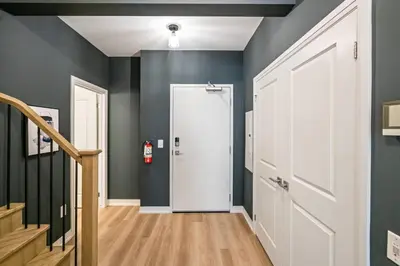 a hallway with a white door and a staircase at 1 Bdrm Luxe Apartment in Niagara in Niagara on the Lake