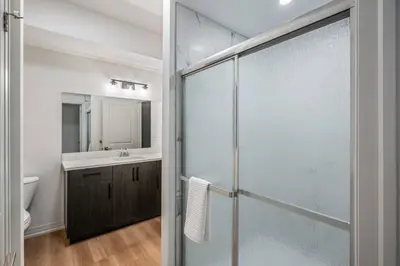 a bathroom with a glass shower and a sink at 2 Bdrm New Stylish Apt for up to 6 ppl in Niagara in Niagara on the Lake