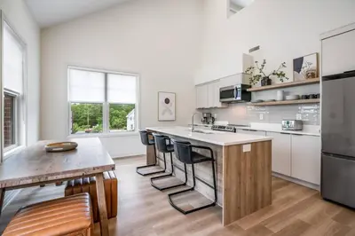 a kitchen with a counter and a table with chairs at 2 Bdrm New Stylish Apt for up to 6 ppl in Niagara in Niagara on the Lake