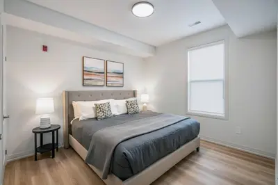 a bedroom with a large bed and a window at 2 Bdrm New Stylish Apt for up to 6 ppl in Niagara in Niagara on the Lake