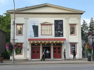 a white building with people standing outside of it at Walk to Old Town | Cottage 3 ppl Top 10% | Parking in Niagara on the Lake