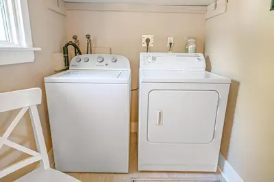 a small laundry room with a washer and dryer at Walk to Old Town | Cottage 3 ppl Top 10% | Parking in Niagara on the Lake