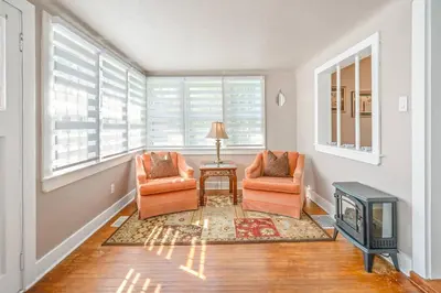 a living room with two chairs and a fireplace at Walk to Old Town | Cottage 3 ppl Top 10% | Parking in Niagara on the Lake