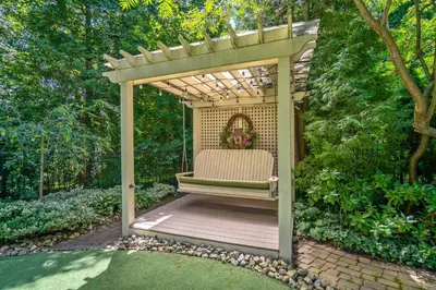 a pergola with a chair sitting on a wooden deck at Hot Tub | Mini Putt | Historic Old Town | 2 Guests in Niagara on the Lake