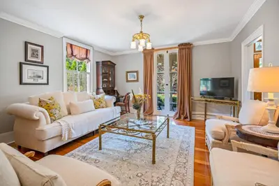 a living room with a white couch and a table at Hot Tub | Mini Putt | Historic Old Town | 2 Guests in Niagara on the Lake