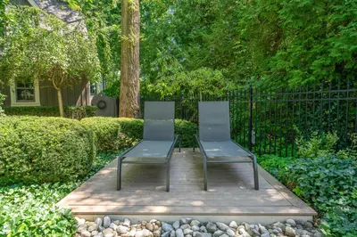 two chairs sitting next to each other in a garden at Hot Tub | Historic Home | Steps to Everything NOTL in Niagara on the Lake