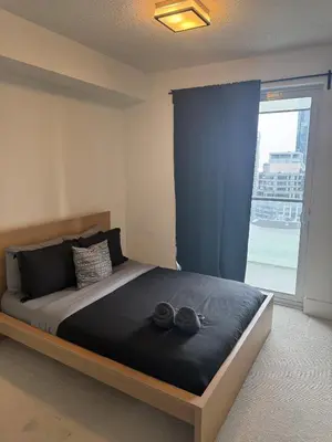 a bedroom with a bed with two pairs of shoes on it at Lush 3 Bedroom Condo by CN Tower - Free Parking in Toronto