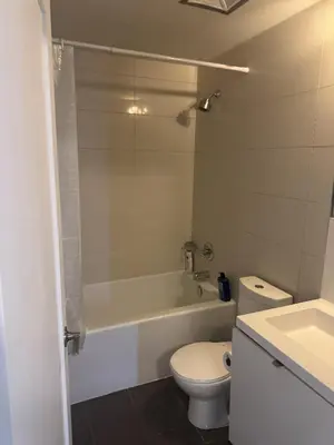a bathroom with a toilet and a tub and a sink at Lush 3 Bedroom Condo by CN Tower - Free Parking in Toronto