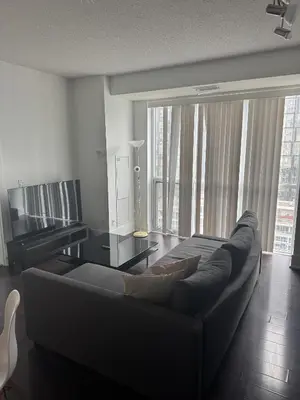 a living room with a couch and large windows at Lush 3 Bedroom Condo by CN Tower - Free Parking in Toronto