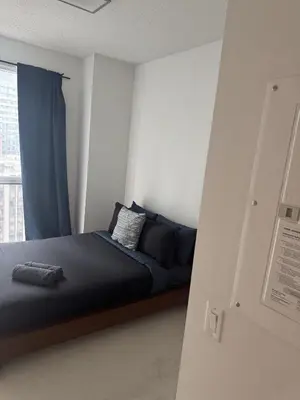 a bed in a room with a window at Lush 3 Bedroom Condo by CN Tower - Free Parking in Toronto