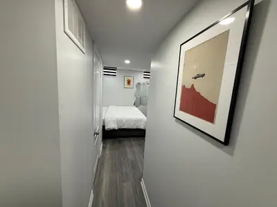 a hallway with a bed and a picture on a wall at Cozy Private Two-Level Suite In Brampton With Separate Entrance And Living Area on Main Floor in Brampton