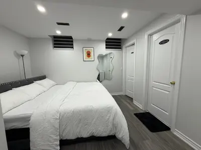 a white bedroom with a bed and a door at Cozy Private Two-Level Suite In Brampton With Separate Entrance And Living Area on Main Floor in Brampton