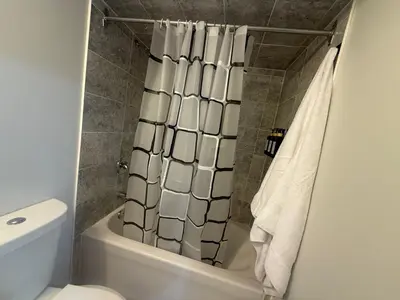a bathroom with a shower curtain and a toilet at Cozy Private Two-Level Suite In Brampton With Separate Entrance And Living Area on Main Floor in Brampton