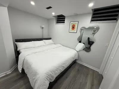 a small bedroom with a bed with white sheets at Cozy Private Two-Level Suite In Brampton With Separate Entrance And Living Area on Main Floor in Brampton