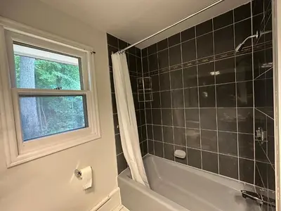 a bathroom with a shower and a tub and a window at Modern Private Room with Bessarion Subway North York in Toronto