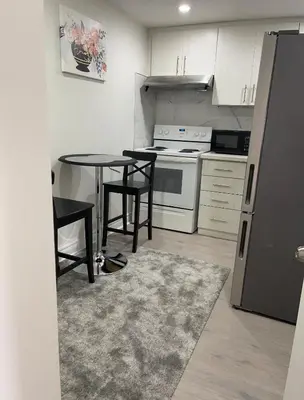 a kitchen with a table and a stove and a refrigerator at Rayann Hospitality in Toronto