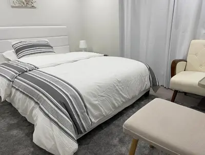 a bedroom with a bed and a chair at Rayann Hospitality in Toronto