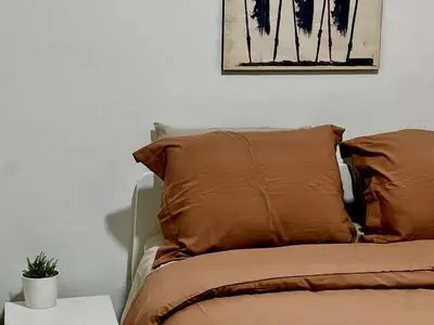 a bed with two pillows and a picture on the wall at Etobicoke Escape in Toronto