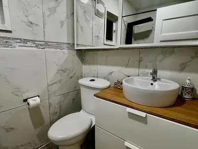 a white bathroom with a toilet and a sink at Etobicoke Escape in Toronto