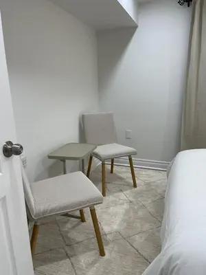 a room with two chairs and a table and a bed at Hanan Hospitality in Toronto
