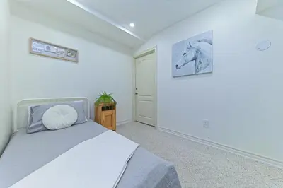 a bedroom with a bed and a picture of a horse on the wall at SPACIOUS & FULLY PVT-2BR UNIT ON GROUND LEVEl in Burlington