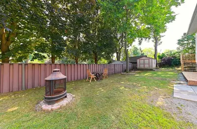 a backyard with a lantern in the grass at SPACIOUS & FULLY PVT-2BR UNIT ON GROUND LEVEl in Burlington