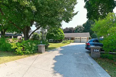 a driveway with a car parked in front of a house at SPACIOUS & FULLY PVT-2BR UNIT ON GROUND LEVEl in Burlington