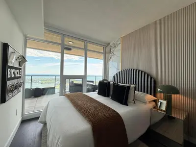a bedroom with a large bed and a large window at Deluxe Suites Downtown Toronto in Toronto