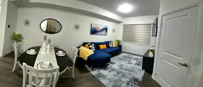 a living room with a blue couch and a table at First Class Ensuite Room in Brantford