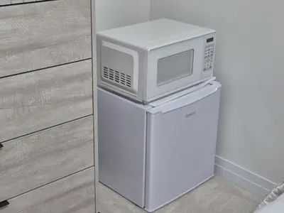 a microwave sitting on top of a refrigerator at First Class Ensuite Room in Brantford