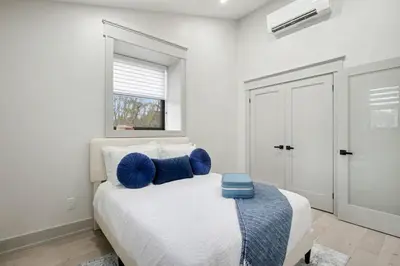 a bedroom with a bed with blue pillows on it at The Wynford Dreamy Capri Suite in Elora