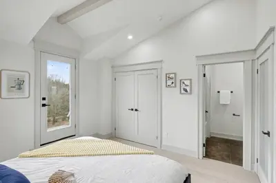 a white bedroom with a bed and a window at The Wynford Dreamy Capri Suite in Elora