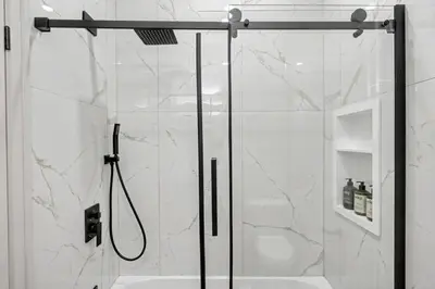a shower with a glass door in a bathroom at The Wynford Dreamy Capri Suite in Elora