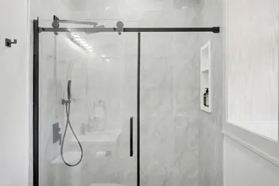 a shower with a glass door in a bathroom at The Wynford Dreamy Capri Suite in Elora