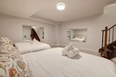 a bedroom with two beds with a stuffed animal on the floor at Charming Mississauga Getaway in Mississauga