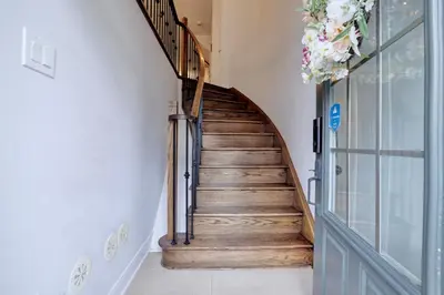 a wooden staircase with a metal handrail in a house at Charming Mississauga Getaway in Mississauga