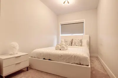 a white bedroom with a bed and a window at Charming Mississauga Getaway in Mississauga