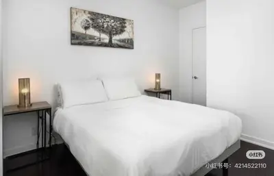 a bedroom with a white bed and two night stands at xto in Markham
