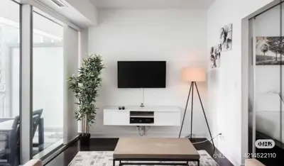 a living room with a tv on a white wall at xto in Markham