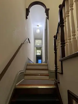 a hallway with stairs and an archway at Klaus Guesthouse in Toronto