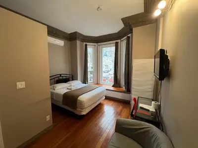 a hotel room with a bed and a window at Klaus Guesthouse in Toronto