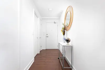 a hallway with white walls and a mirror on a wall at 2 bedrooms Downtown Toronto Free parking in Toronto