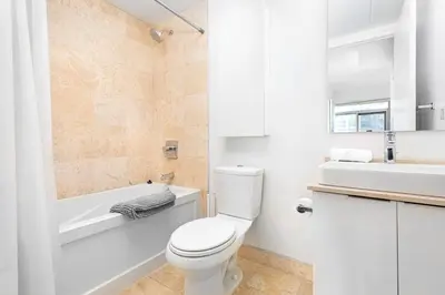 a bathroom with a toilet and a tub and a sink at 2 bedrooms Downtown Toronto Free parking in Toronto